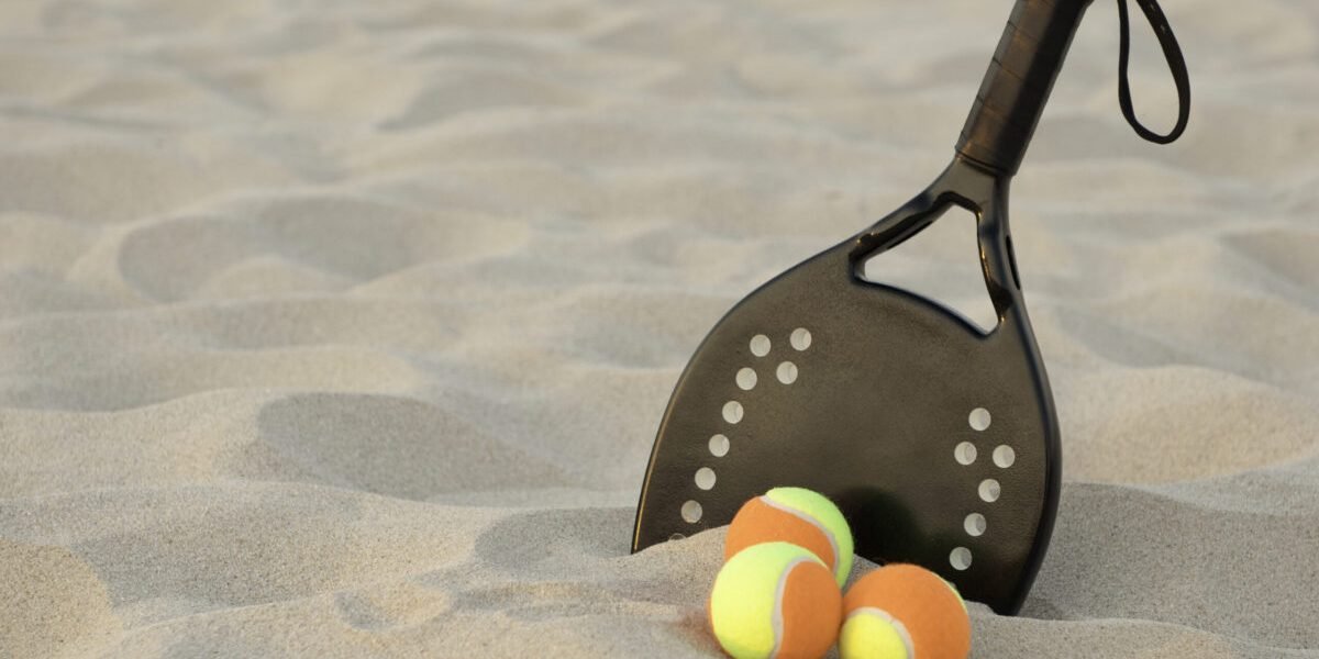 Beach tennis racket in sand